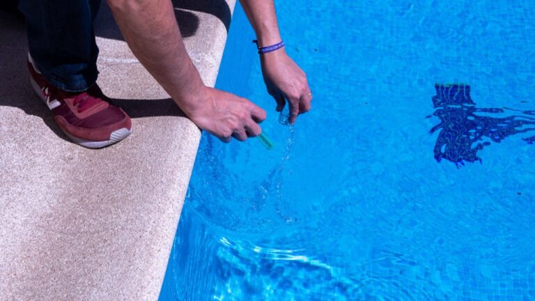 Técnico municipal tomando una muestra de agua para el control sanitario de una piscina en Boadilla del Monte.